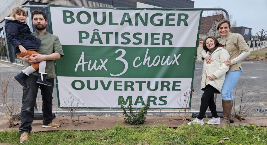 Clément et Sophie avec leurs filles devant la banderole d’ouverture du deuxième point de vente AUX 3 CHOUX à Saint-Amand-Montrond en mars 2024.