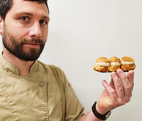 photo du chef tenant le gâteau emblématique de la maison aux 3 choux
