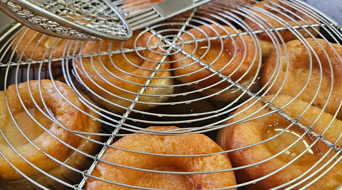 Photo de biscuits savarin qui trempent dans un sirop au rhum