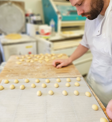 photo du chef Clément de la maison aux 3 choux exécutant des boules avec la pâte à navette