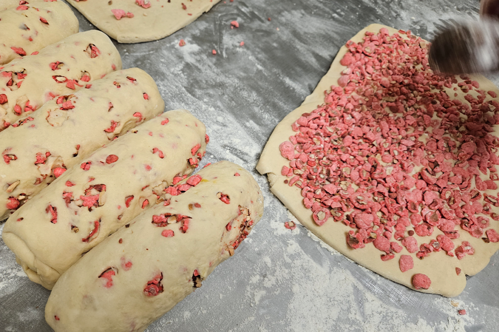 photo montrant la suite du travail de l'intégration des pralines roses dans la pâte à brioche