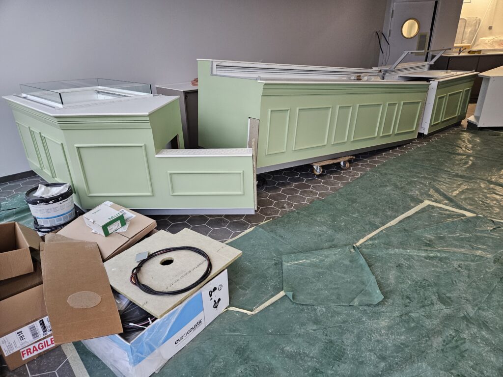 Installation des vitrines de présentation dans la nouvelle boutique Aux 3 Choux lors de l’aménagement du second point de vente à Saint-Amand-Montrond.