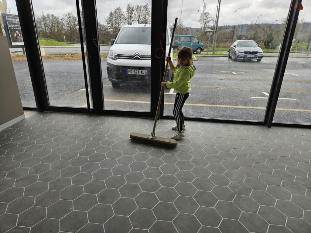 Fille de la famille Aux 3 Choux participant au nettoyage de la nouvelle boulangerie après les travaux avant l’ouverture du second point de vente à Saint-Amand-Montrond