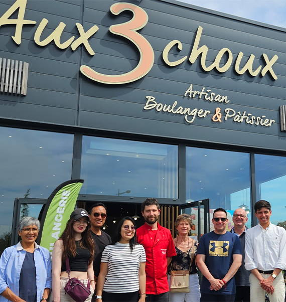 Rencontre entre le chef Clément Policard des Aux 3 Choux et une délégation de Riobamba en Équateur devant la boulangerie à Saint-Amand-Montrond.